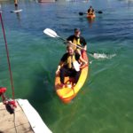 A group of people kayaking in the water while participating in a small business marketing workshop.