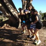 A group of people participating in a small business marketing workshop next to a tree.