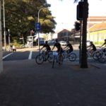 A group of people participating in a marketing workshop while riding bicycles in a city.