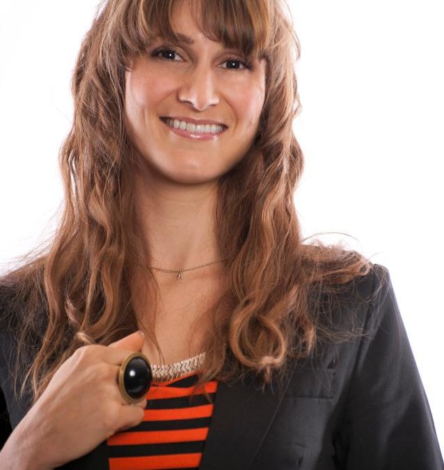 A woman in a black blazer and striped shirt attends a marketing workshop for small business marketing.