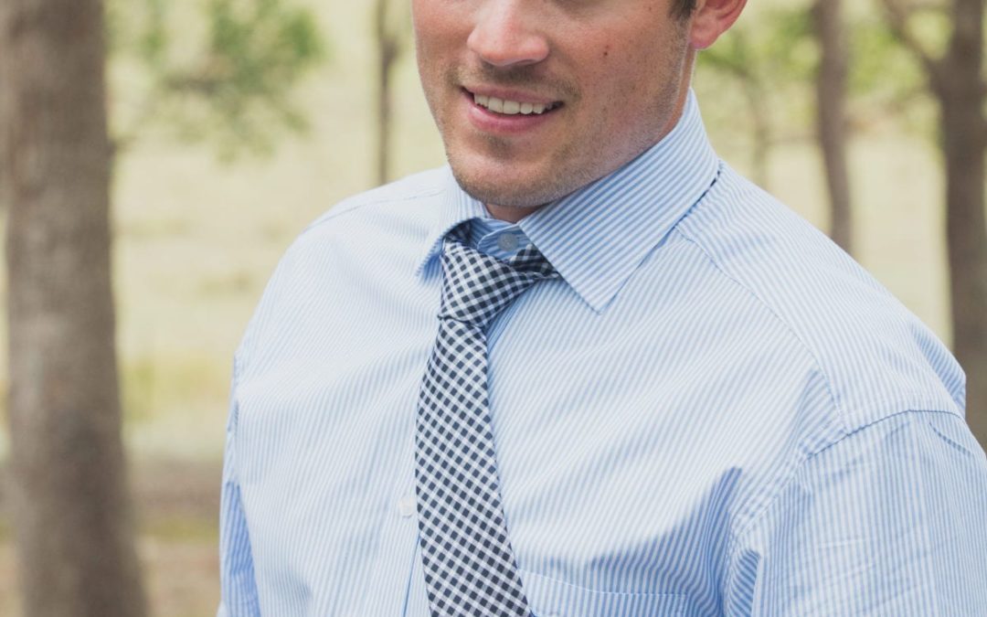 A man in a blue shirt and tie, attending a marketing workshop.