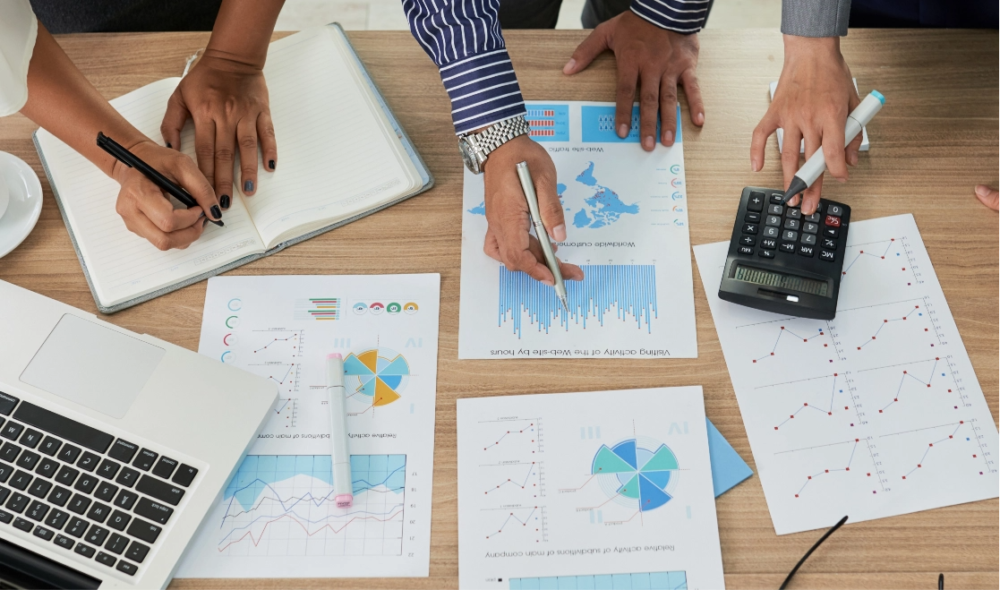 A group of business people participating in a marketing workshop, analyzing graphs and discussing their small business marketing strategies.